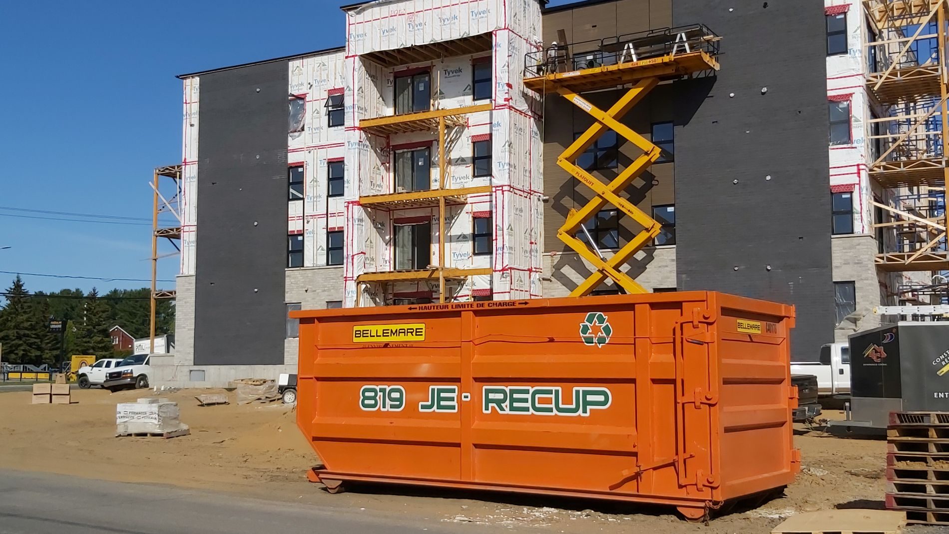 Chantier de construction propre au Québec avec conteneur de tri des déchets